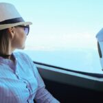 Pasażerka w kapeluszu siedzi w autobusie i wygląda przez okno