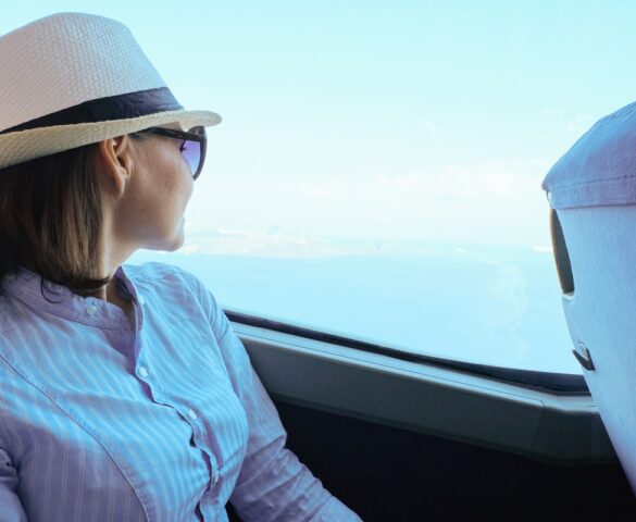 Pasażerka w kapeluszu siedzi w autobusie i wygląda przez okno